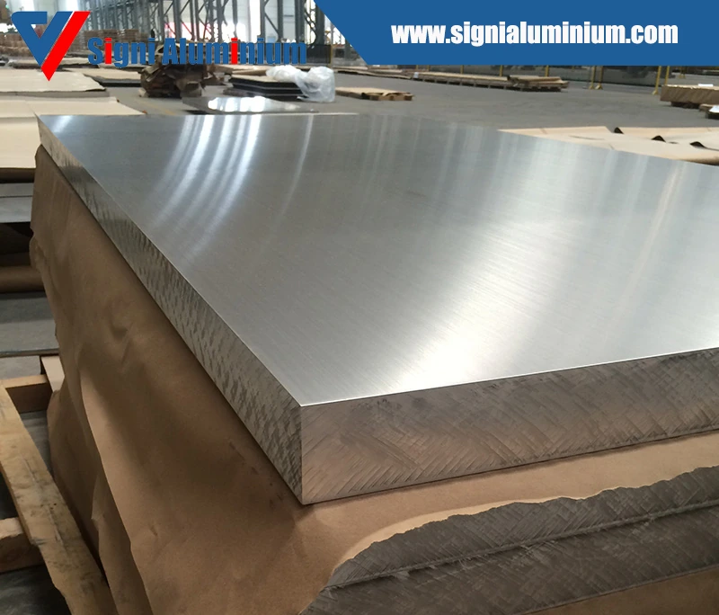 Thick marine-grade aluminium plates stacked on a pallet with paper interleaving