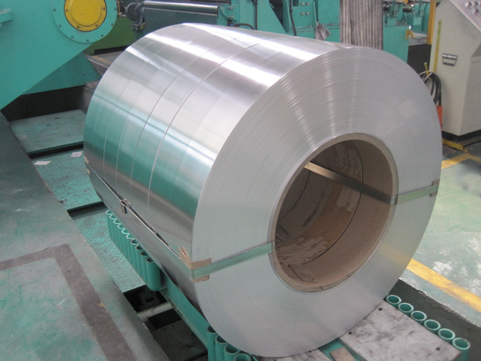 Une grande bobine mère d'aluminium sur un chariot de bobines dans une usine de laminage
