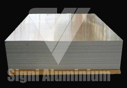 A neat stack of flat aluminium plate blanks on a dark background
