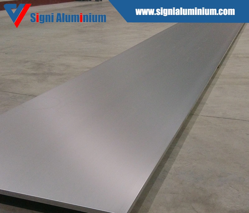 A long polished aluminium sheet lying on a concrete floor