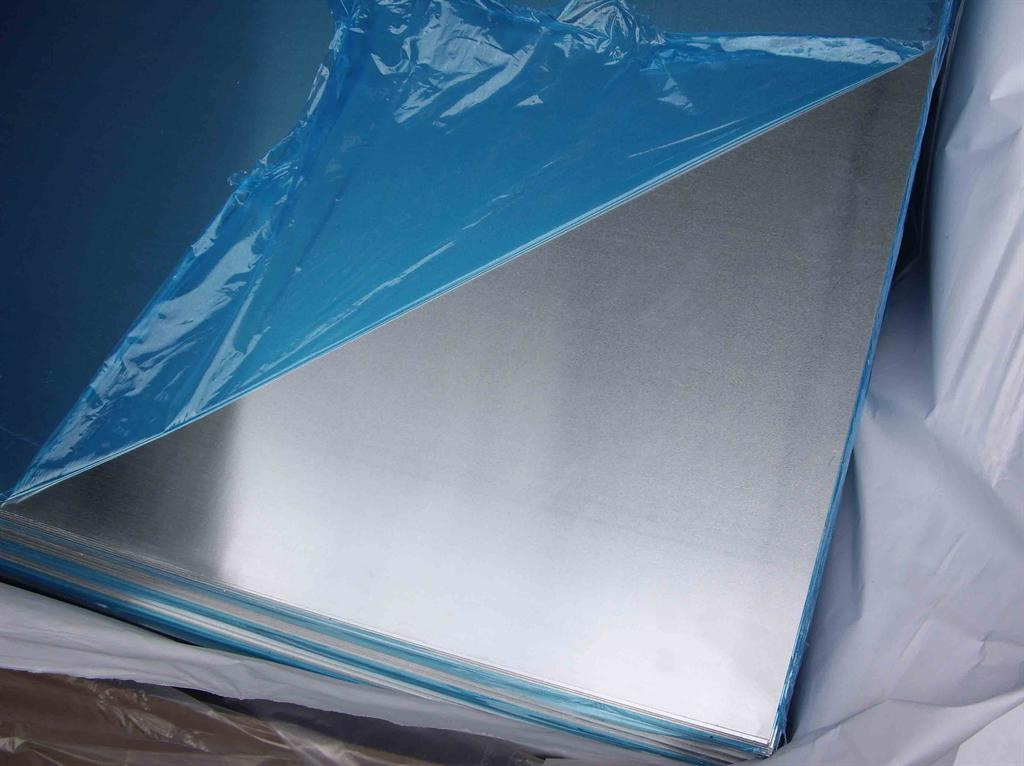 A stack of aluminium sheets with blue protective film partly peeled back